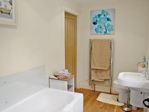 a bathroom with a tub and a toilet and a sink at Heathfield in Denholm