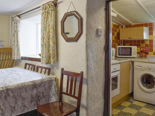 a kitchen with a table and a sink and a microwave at Ty-gwyn in Brondini