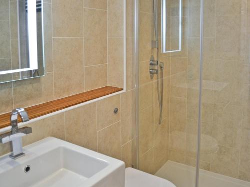 een badkamer met een douche, een wastafel en een toilet bij Dyji in St Just