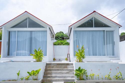 biały dom z niebieskimi oknami i schodami w obiekcie Jempana View w mieście Kintamani