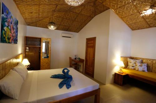 a bedroom with a bed with a blue towel on it at Magic Oceans Dive Resort in Anda