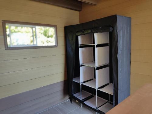 a black cabinet in a room with a window at Glamping Tiny house 