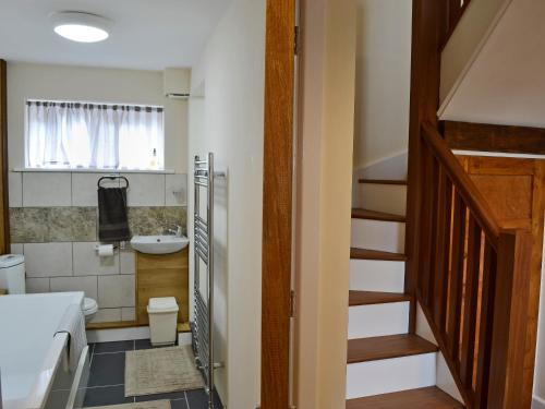 a bathroom with a staircase leading to a toilet and a sink at Oak House in Rhewl