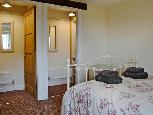 a bedroom with a bed with two pillows on it at Oak House in Rhewl