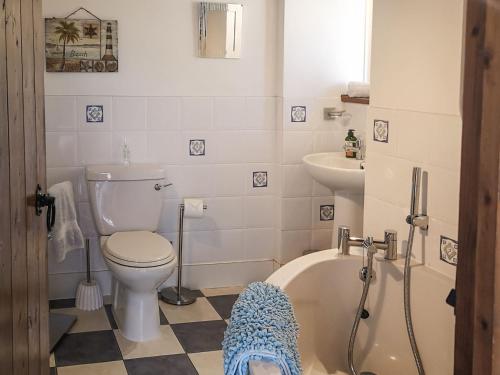a bathroom with a toilet and a tub and a sink at Elm Barn Lodge in Southampton