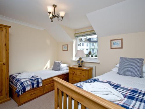 a bedroom with two beds and a window at 52 Moorings Reach in Brixham