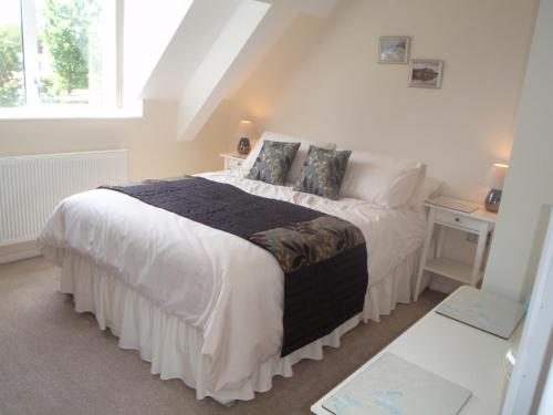 a bedroom with a large bed with white sheets and pillows at Holy Waters in Staveley