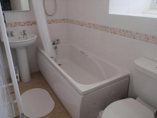 a bathroom with a tub and a sink and a toilet at Holy Waters in Staveley