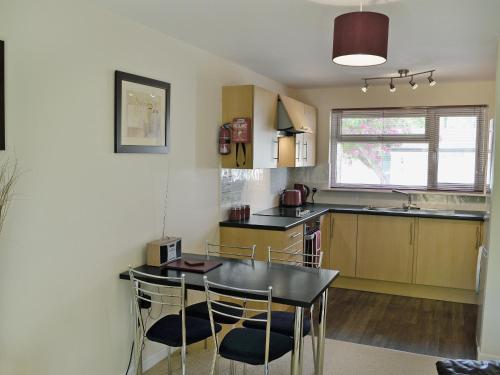 cocina con mesa y sillas en una habitación en Seaton, en Saint Cleer