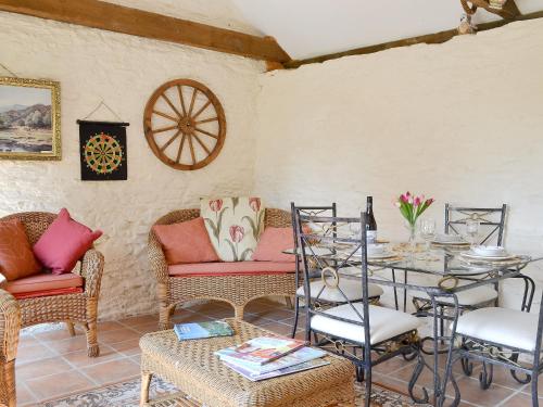 a living room with a table and chairs and a tableablish at Forget Me Not Cottage in New Radnor