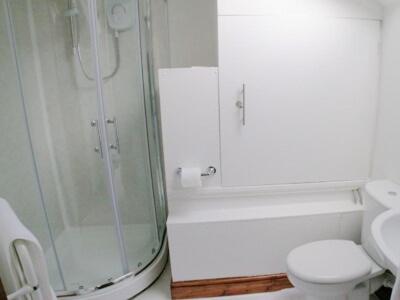 een badkamer met een douche, een toilet en een wastafel bij Jebel Kasr in Braithwaite