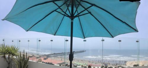 una sombrilla azul frente a una vista de la playa en Best View of Pimentel, en Pimentel