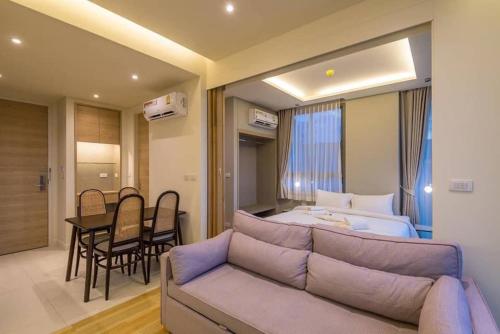 een kamer met een bank, een bed en een tafel bij CORNER SEA VIEW KRABI Ao Nang 4 STARS HOTEL RESIDENCE in Ao Nang Beach