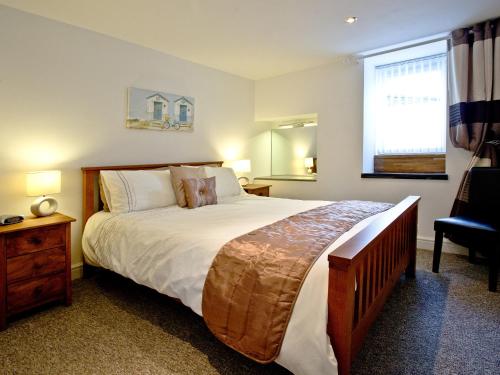 a bedroom with a large bed and a window at Devon Villa Garden Apartment in Torquay