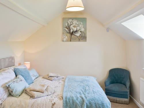 een slaapkamer met een bed en een blauwe stoel bij Thornhill in Whitchurch