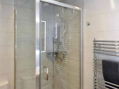 a shower with a glass door in a bathroom at Lavender Cottage was Fellside in Melmerby