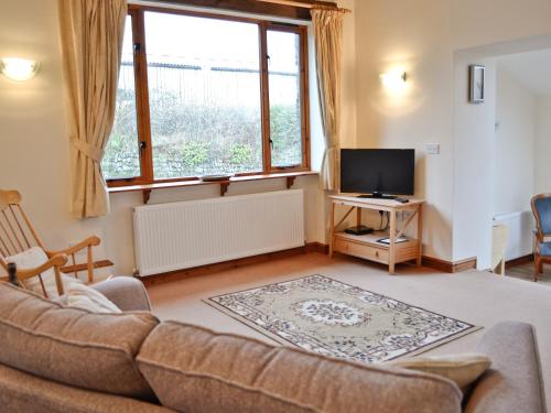 uma sala de estar com um sofá e uma televisão em Taw em Great Torrington
