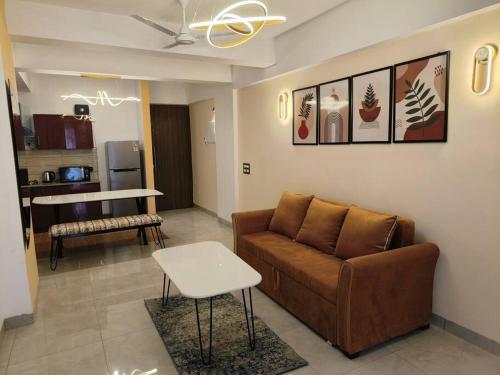 a living room with a couch and a table at The Himalayan Haven- Luxury 1 BHK Apartment in Rājpur