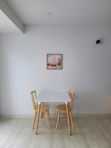 a table with four chairs and a painting on a wall at Gold Coast Luxury Apartment Nha Trang in Nha Trang