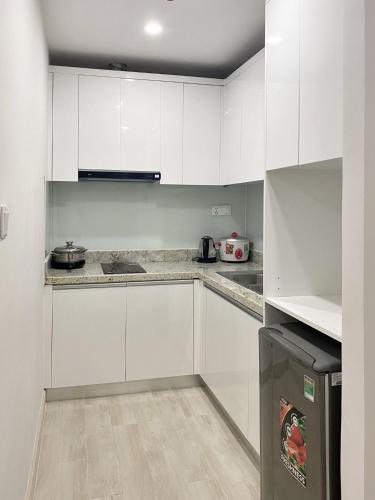 a white kitchen with white cabinets and a stove at Gold Coast Luxury Apartment Nha Trang in Nha Trang