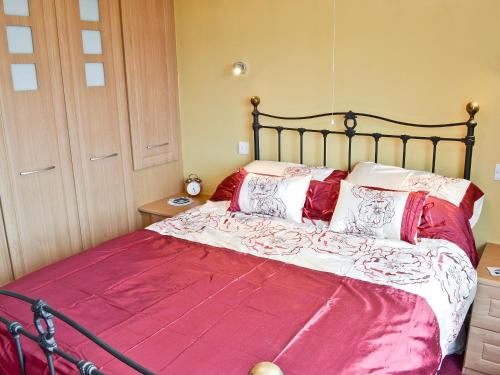 a bedroom with a large bed with a red blanket at Mount Lea in Hinderwell