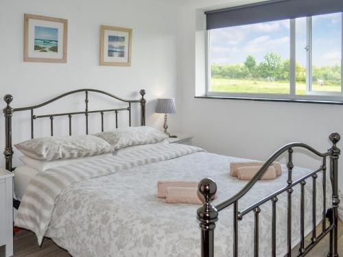 a bedroom with two beds and a window at Sunny Skies in St Austell