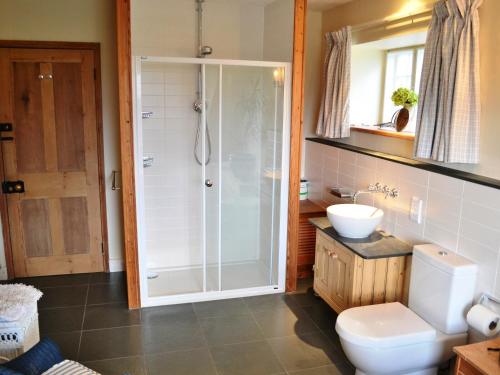 a bathroom with a shower and a toilet and a sink at Overwater Lodge in Bassenthwaite Lake