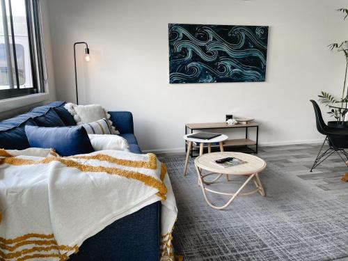 a living room with a blue couch and a table at Beachcomber Holiday Units in Lakes Entrance