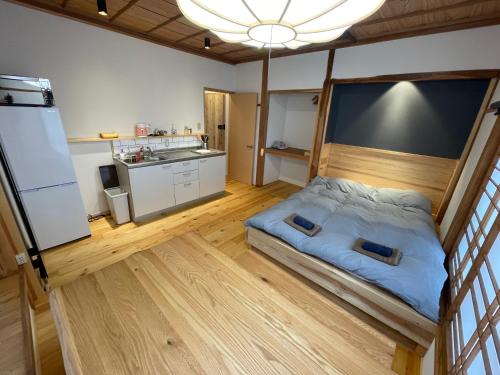 a small bedroom with a bed and a kitchen at Yubaba House Downtown Apartments in Nozawa Onsen
