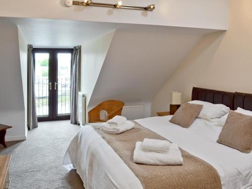 a bedroom with a large bed with towels on it at Harbour View in Castletown