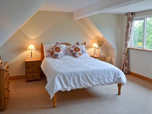 - une chambre avec un lit, deux lampes et une fenêtre dans l'établissement Kiln Cottage, à Rye