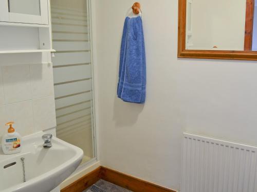 a bathroom with a sink and a towel hanging on the wall at Kiln Cottage in Rye