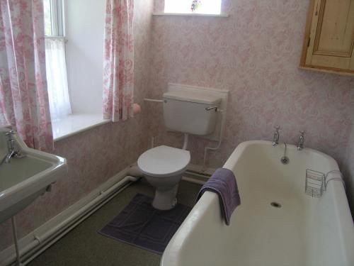 La salle de bains est pourvue de toilettes, d'une baignoire et d'un lavabo. dans l'établissement 3 Townhead Cottages, à Grasmere