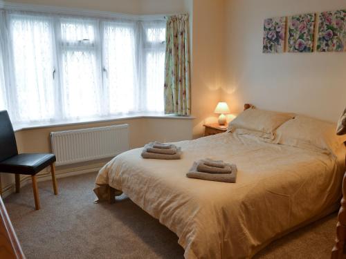 a bedroom with a bed with two towels on it at Hideaway Cottage in Kingsgate