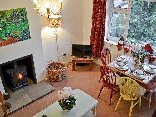a living room with a table and a fireplace at Cedars in Fordwich