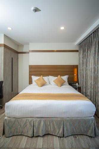 a bedroom with a large white bed with pillows at Hotel X Rajendrapur Gazipur in Gazipur