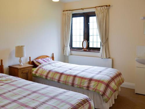 a bedroom with two beds and a window at Canon Court Farm in Haydon