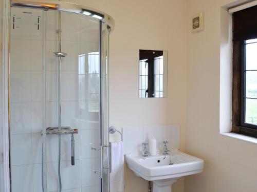 a white bathroom with a sink and a shower at Canon Court Farm in Haydon