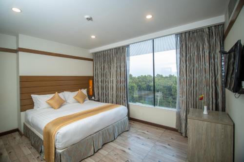 a bedroom with a bed and a large window at Hotel X Rajendrapur Gazipur in Gazipur