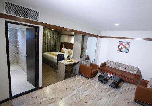 a hotel room with a bed and a living room at Hotel X Rajendrapur Gazipur in Gazipur