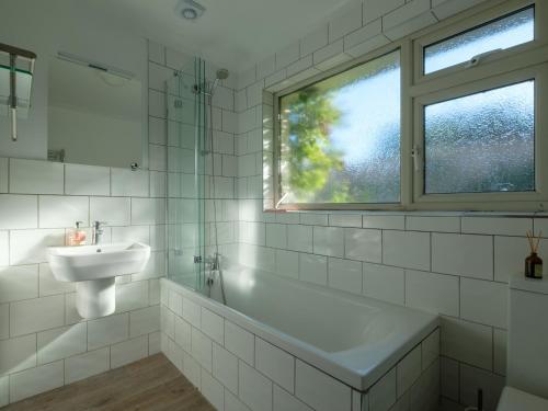 a bathroom with a sink and a bath tub and a window at Greenridge in Totland