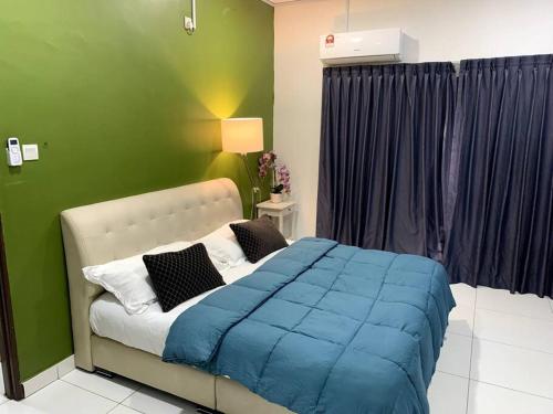 um quarto com uma cama com um cobertor azul em Hud-Hud Homestay 2 Gelang Patah em Gelang Patah