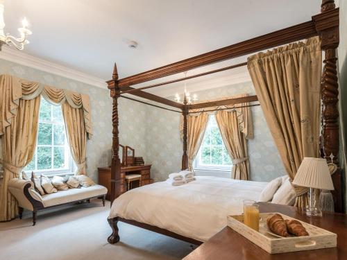 um quarto com uma cama de dossel e uma mesa em Northolme Hall em Wainfleet All Saints