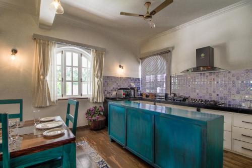a kitchen with a blue island in the middle at Villa Beleza Infinita in Mapusa