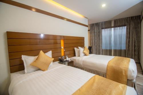 a hotel room with two beds and a window at Hotel X Rajendrapur Gazipur in Gazipur