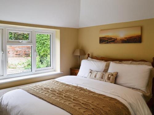 a bedroom with a bed and two windows at Reedcutters in Reedham