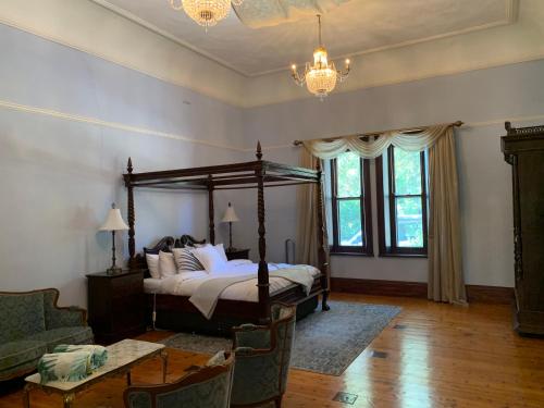 a bedroom with a bed and a chandelier at Bungala House in Yankalilla