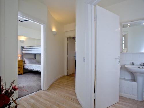 een witte badkamer met een wastafel en een spiegel bij 2 Fishermans Loft in Brixham