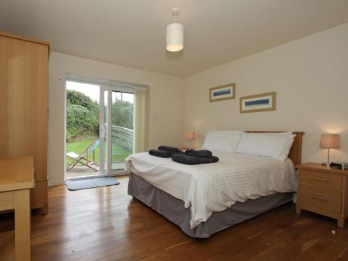 um quarto com uma cama e uma grande janela em 9 Glendorgal em Saint Columb Minor
