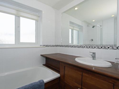 uma casa de banho branca com um lavatório e uma banheira em 9 Glendorgal em Saint Columb Minor